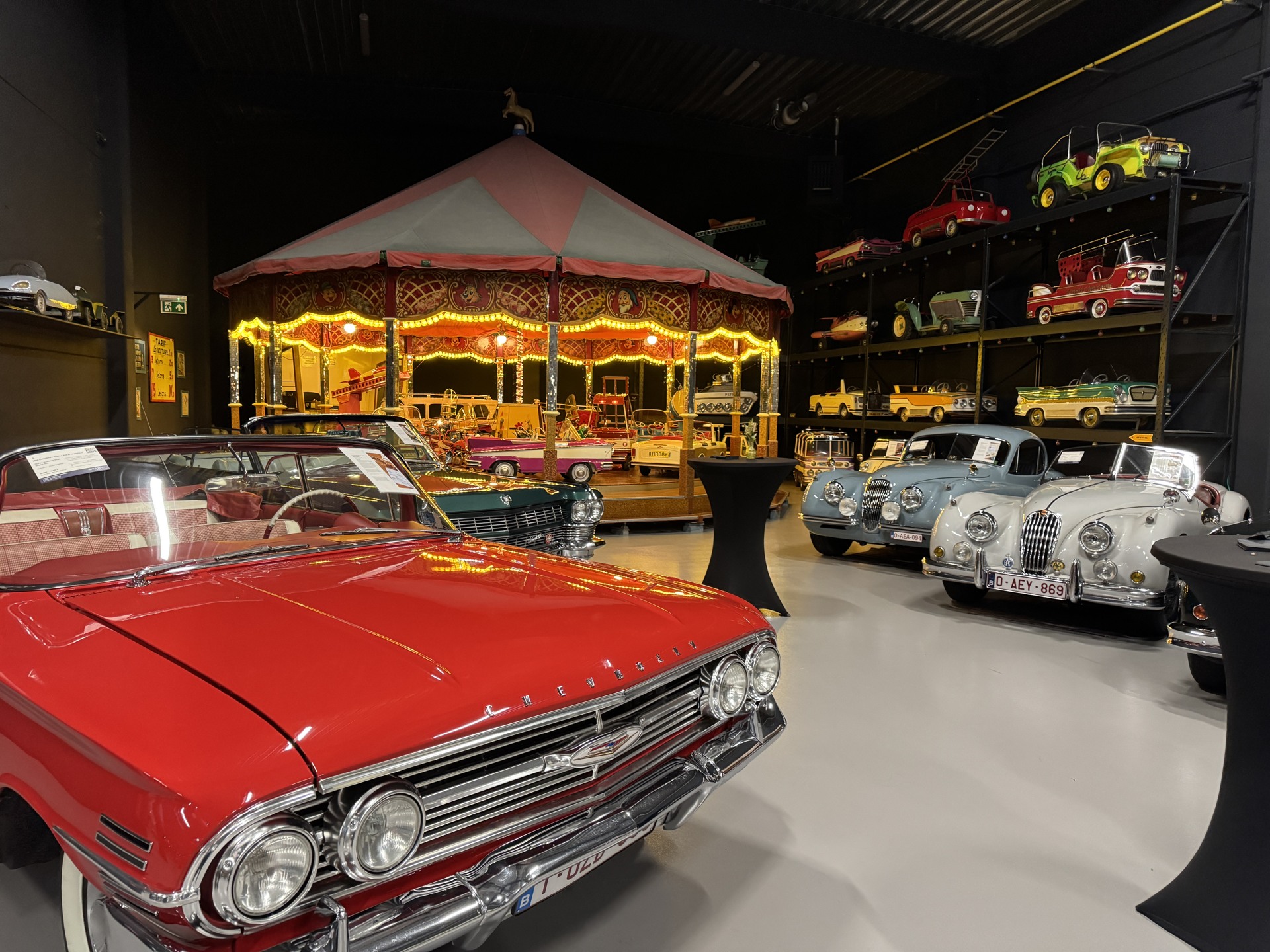 Illuminated carousel with classic cars around it