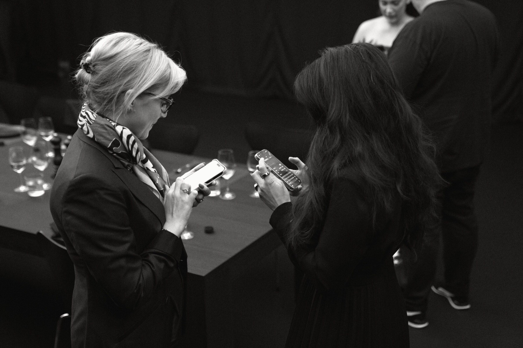 Two guests comparing notes on their phones.