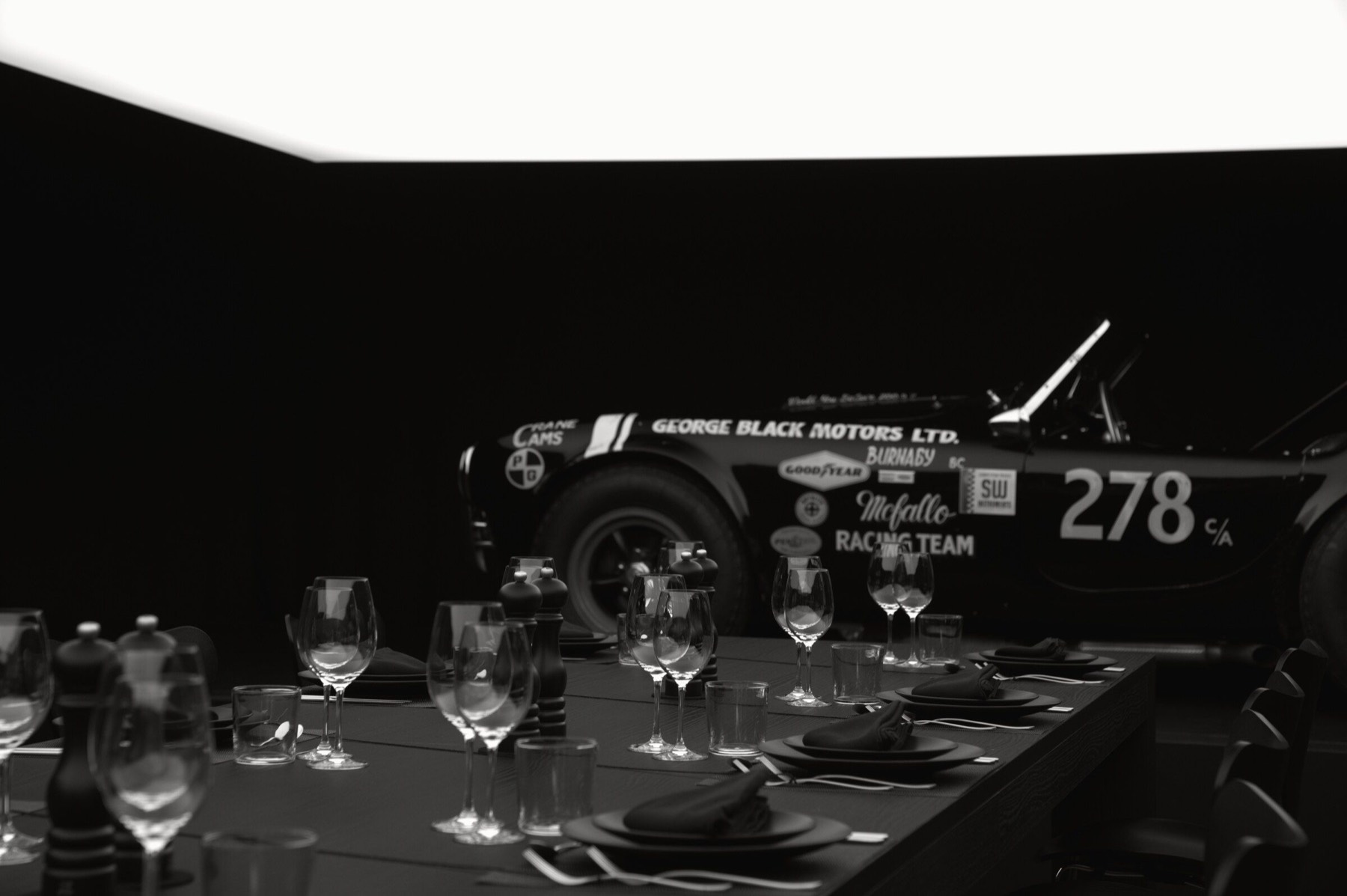 The fully prepared table with a historic race car behind it.