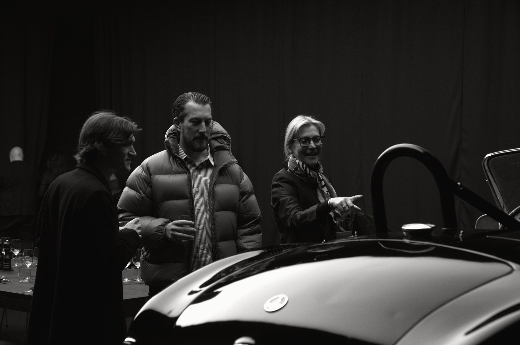 Laura Kukuk von Glahn discussing a collector car with guests.