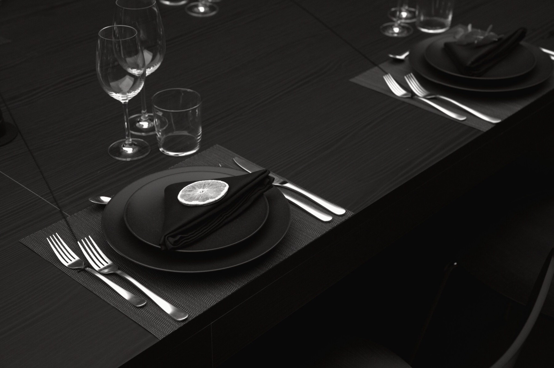 A restrained black place setting prepared for the light dinner.